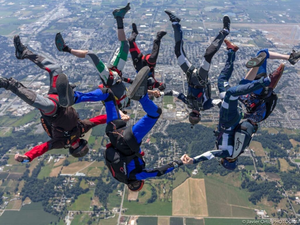 Aerial view of skydivers in mid-air, descending with parachutes after jumping from plane
